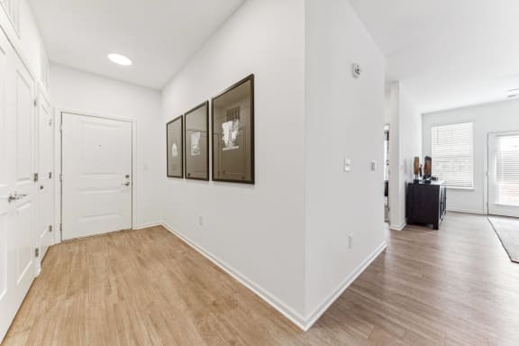 the living room and entryway of a home with white walls and wood floors  at Plat 4 at Research Triangle, North Carolina