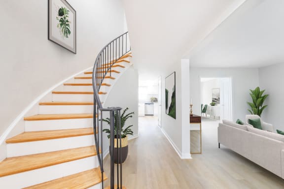 a spiral stairway in a living room with a house plant