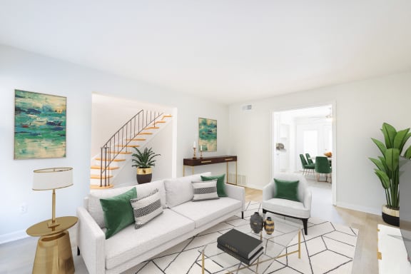 a living room with a white couch and green pillows