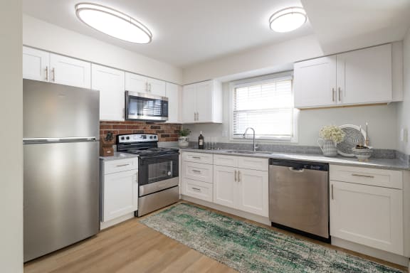 a kitchen with stainless steel appliances and white cabinets