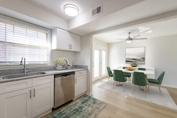 a kitchen and dining room with white cabinets and a table and chairs