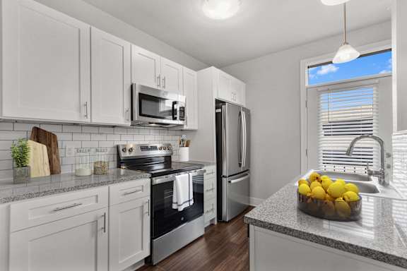 A kitchen with white cabinets and a granite countertop at CityWay Apartments, Indianapolis, Indiana