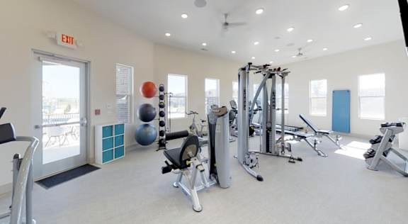 A gym with a variety of equipment including a treadmill, weights, and a squat rack. at Echo Park at Perry Crossing Apartments, Plainfield