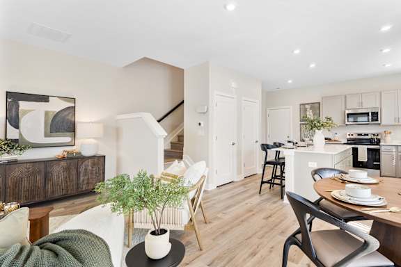 A modern kitchen with a dining table set for two.
