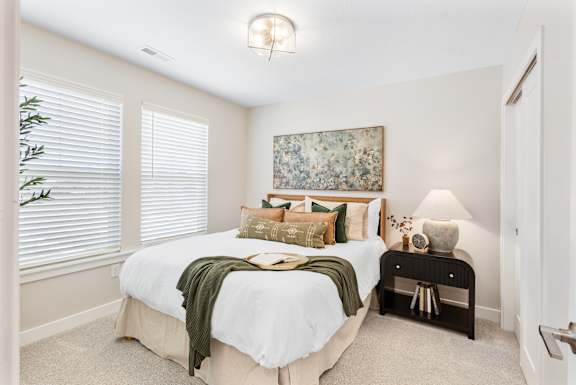 A bedroom with a large bed and a painting on the wall.