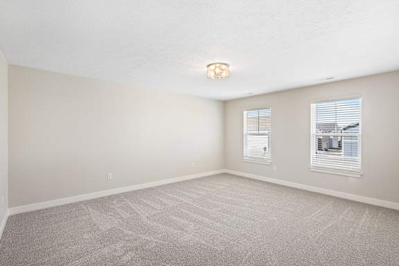 A room with a carpeted floor and two windows. at Mural Lewis Center, Ohio