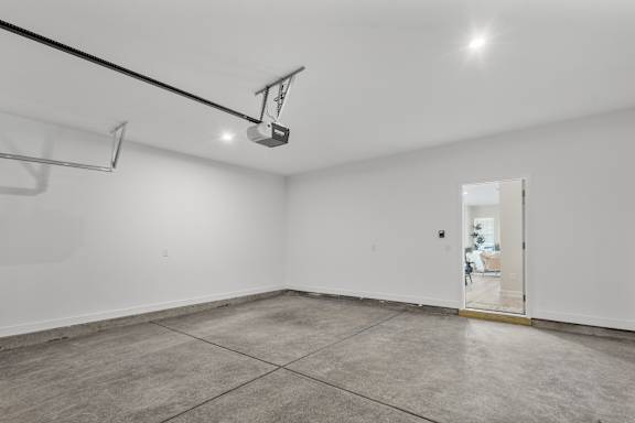 A white room with a door and a light on the ceiling.