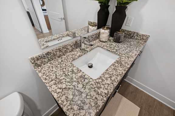Elegant bathroom vanity at Nook Nine with granite countertops, modern fixtures, and ample storage.