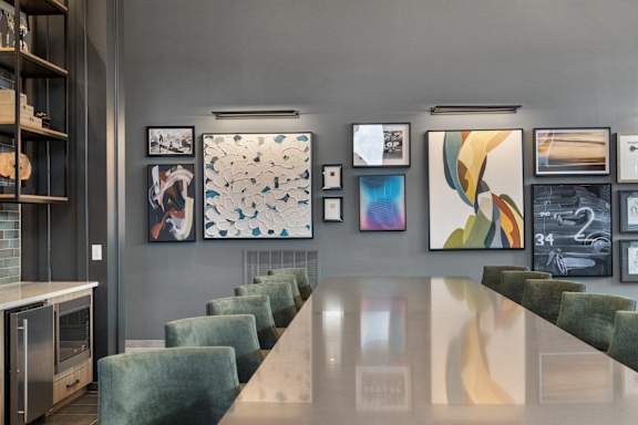 Clubhouse at Nook Nine with modern artwork, sleek dining table, and plush seating.