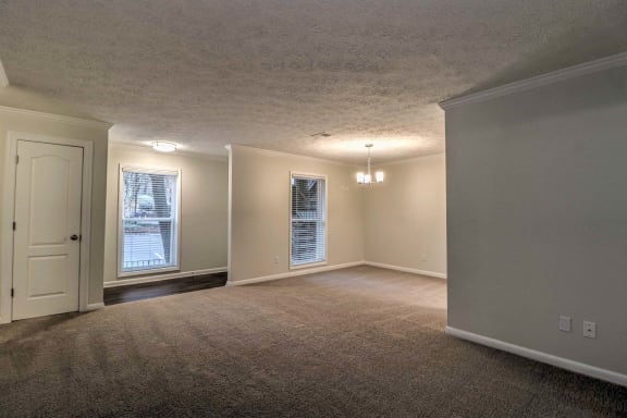 the living room and dining room of an empty home