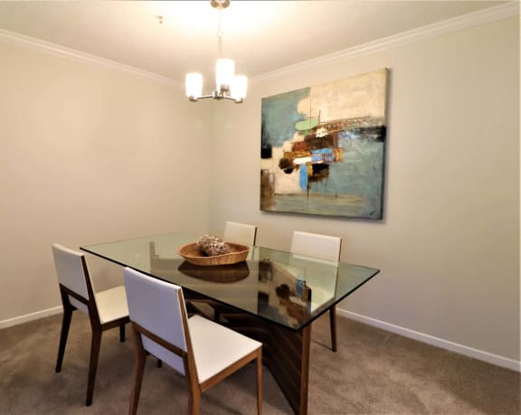 a dining room with a glass table and chairs