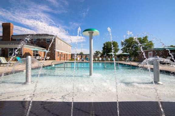 A water fountain in the middle of a pool surrounded by buildings at Gramercy Apartments, Indiana