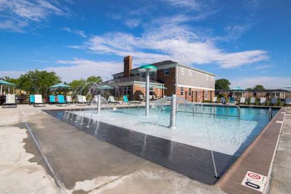 A large outdoor swimming pool with a building in the background at Gramercy Apartments, Carmel, IN