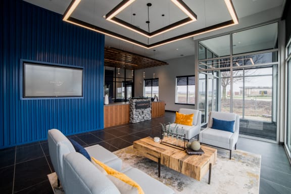 a living room with blue and white furniture and a coffee table at The Century at Purdue Research Park-Student, West Lafayette, IN 47906