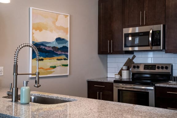 a kitchen with granite counter tops and a sink at The Century at Purdue Research Park-Student, West Lafayette Indiana