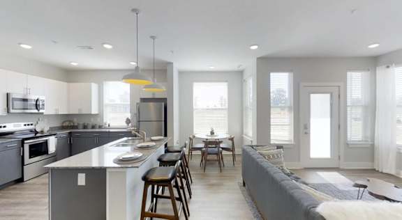 A modern kitchen with a large island and a dining area at Echo Park at Perry Crossing Apartments, Plainfield, 46168