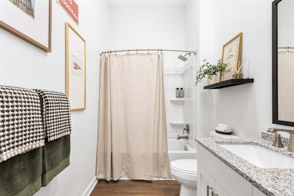 A bathroom with a toilet, sink, and shower.