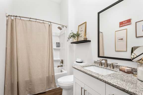 A bathroom with a toilet, sink, and shower curtain.