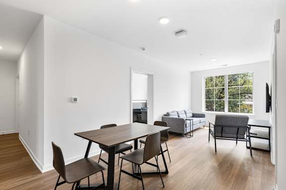 A modern dining room with a wooden table and chairs.
