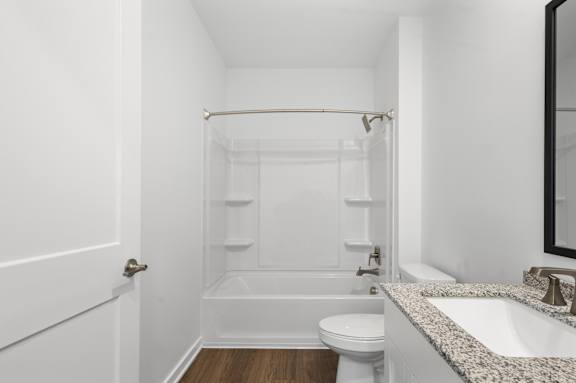 A white bathroom with a toilet, sink, and bathtub.