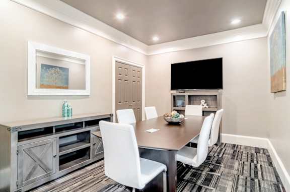 Modern resident conference room with sleek furnishings, a large table, and a mounted TV at Village at Almand Creek apartments in Conyers, GA. Perfect for meetings and remote work.