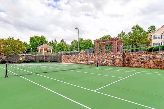 Outdoor tennis court with scenic landscaping and community amenities at Village at Almand Creek apartments in Conyers, GA. Perfect for recreation and active living.