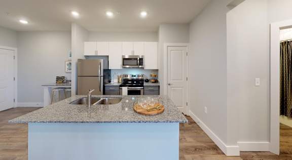 A kitchen with a granite countertop and a blue island at Echo Park at Perry Crossing Apartments, Plainfield, IN