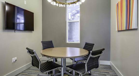 A conference room with a table, chairs, and a television. at Echo Park at Perry Crossing Apartments, Indiana