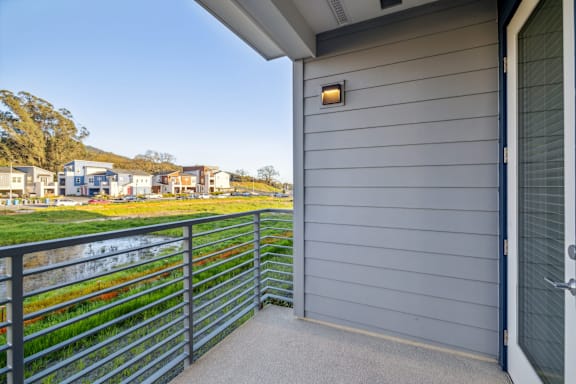 A grey house with a balcony overlooking a grassy area at 38° NORTH, CA, 95404