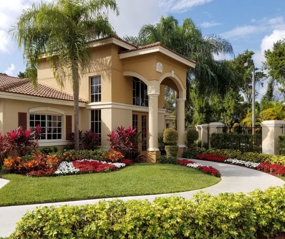 a home with a round driveway and palm trees at Hibiscus Pointe, Miami