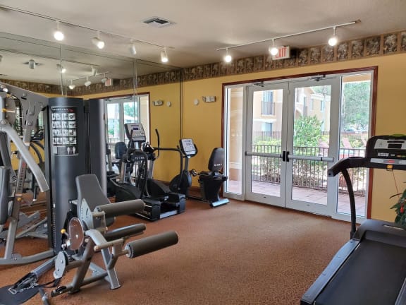 Gym with cardio and weight  fitness equipment at Bernwood Trace Apartments, Fort Myers, Florida