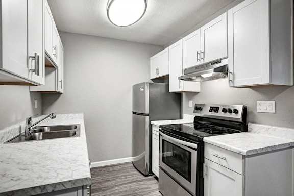 A kitchen with a stove, oven, and sink.