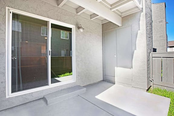 A patio area with a white door and a window.