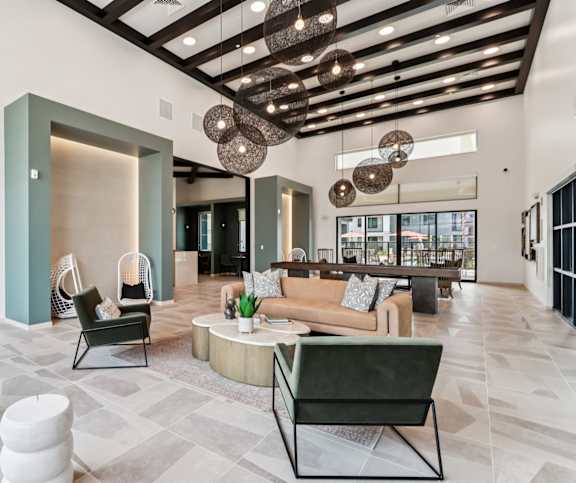 A modern living room with a green chair and a brown couch at Ironwood Ranch Apartments,Maricopa,AZ