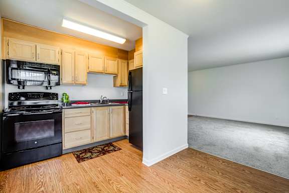 A kitchen with black appliances and wooden cabinets.at Lake Washington Apartments, Seattle
