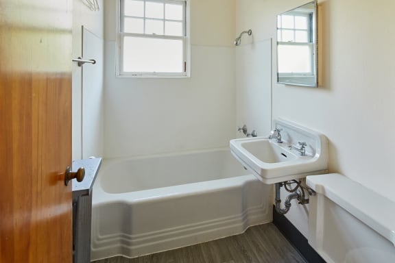 a bathroom with a white bathtub and a white sink at MILEPOST 5 Apartments, PORTLAND, OR