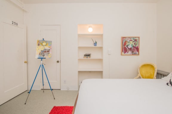a bedroom with a bed and a painting on a tripod at MILEPOST 5 Apartments, PORTLAND, 97213