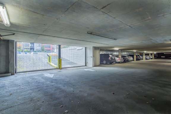 A parking garage with a yellow gate and a concrete floor.