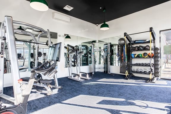 a fitness room with cardio equipment and weights