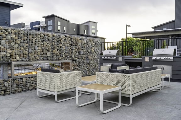 a furnished patio with a fire pit and outdoor furniture