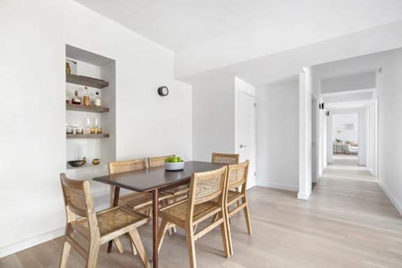 A dining room with a table and chairs.