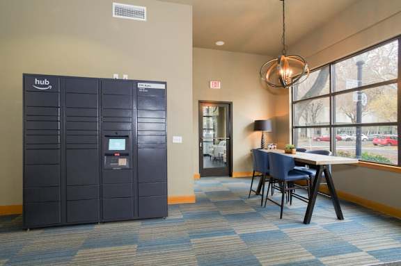 A room with a large black locker and a table with chairs.