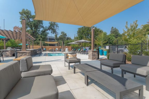 Pool and spa area with seating and BBQ Cedar Flats Chico Apartments