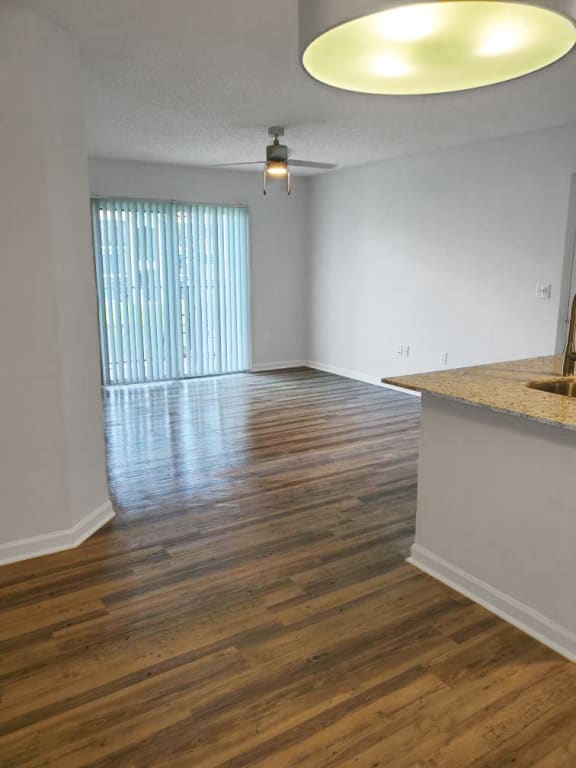 San Marco apartment home living area with balcony and ceiling fan with lots of natural lighting at San Marco Apartments, Ormond Beach, FL
