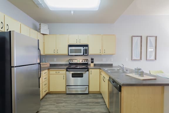 A kitchen with a stove, oven, refrigerator, and microwave.
