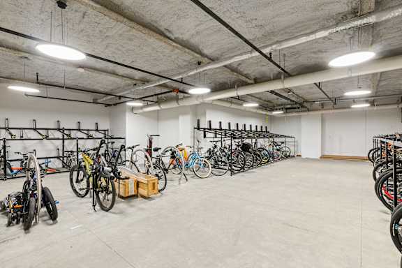 A bike storage room with many bikes on racks at Trio Newton Apartments, Newton, MA, 02460
