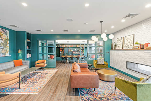 A living room with a grey sofa and a green armchair at Trio Newton Apartments, Newton, 02460