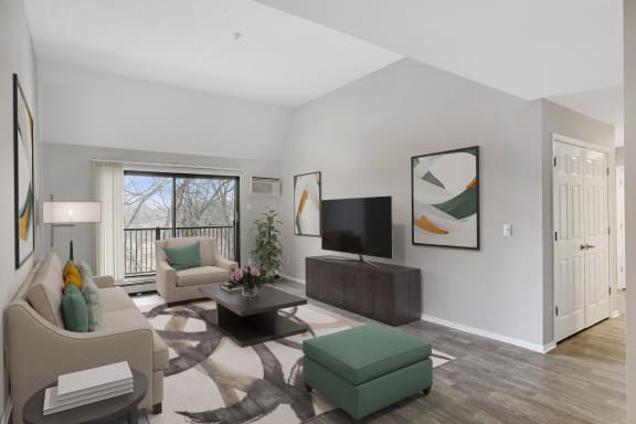 the living room of an apartment with couches and a tv