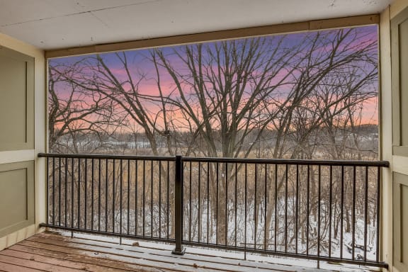 a balcony with a view of a river at sunset