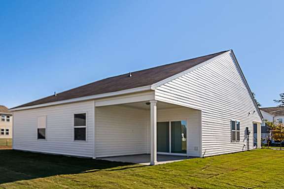 A white house with a brown roof and a covered patio.